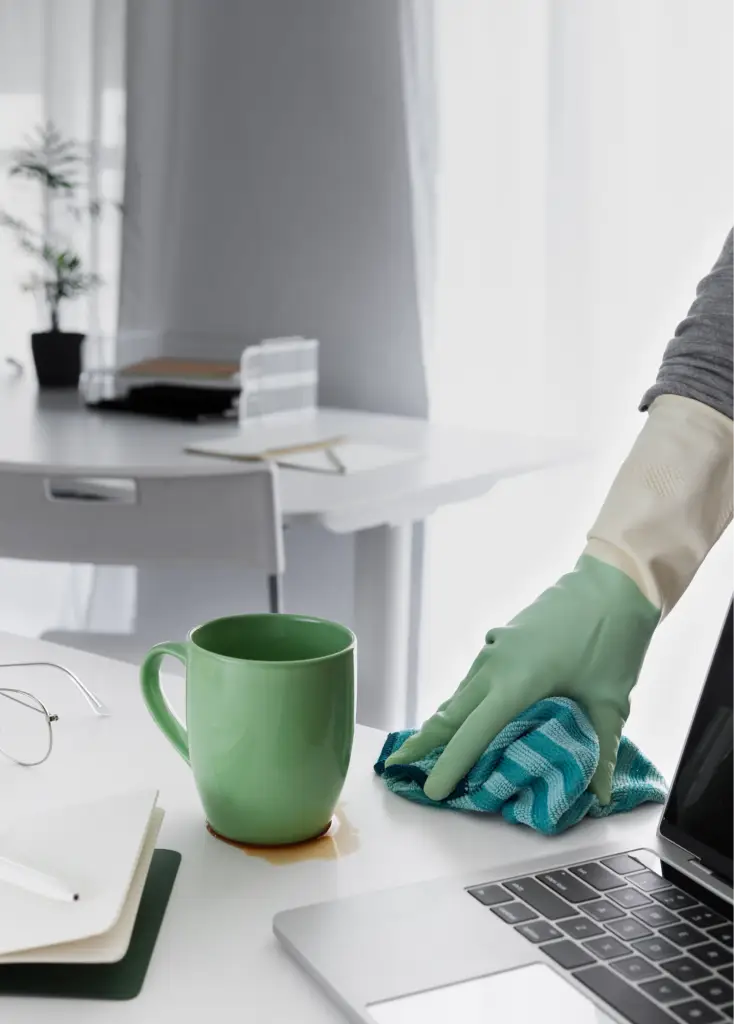 Nettoyage d'une tache de café sur un bureau blanc.