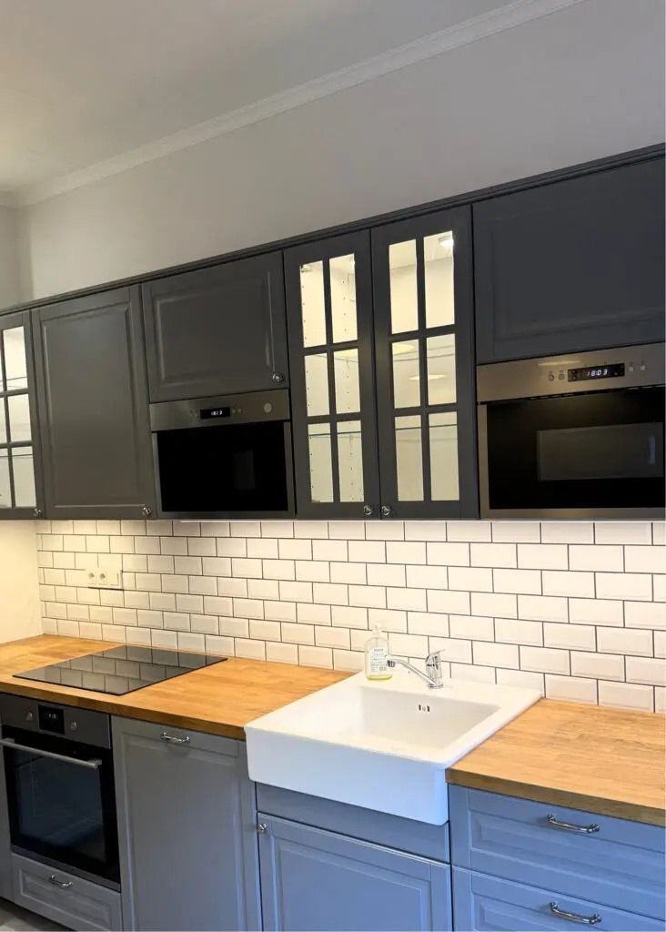 Cuisine moderne grise avec plan de travail en bois naturel.